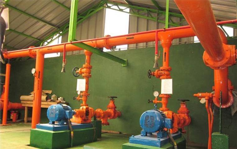 Sala de bombas con líneas de cañerías petroleras pintadas en naranja